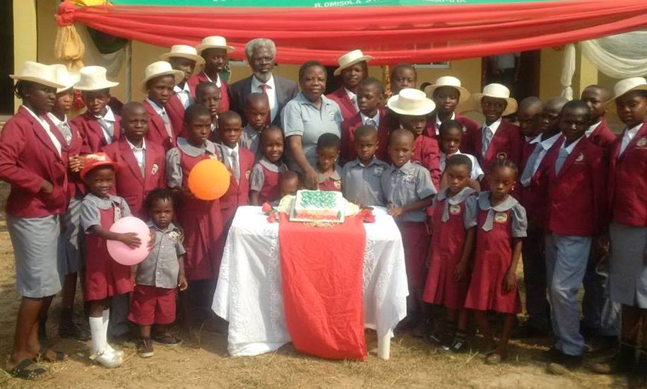 Fadugba with Ayodele and pupils of the school cutting the Christmas cake.